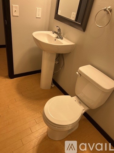 A white toilet sits next to a white sink in a bathroom.