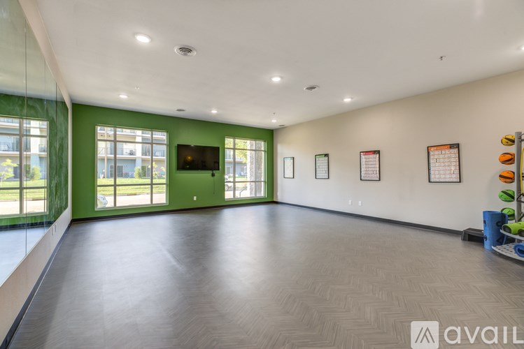 A spacious room with a green door and a flat screen TV mounted on the wall.