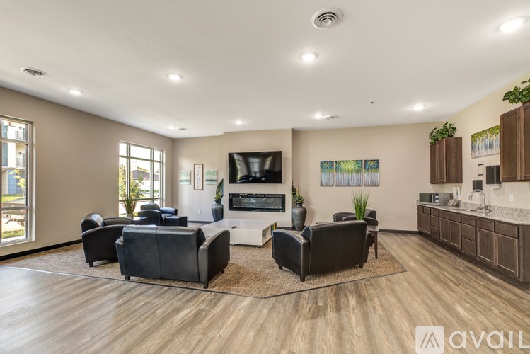 A spacious living room with a television, couches, and a wooden floor.