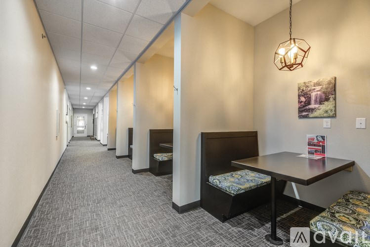 A long hallway with a table and chairs at the end.