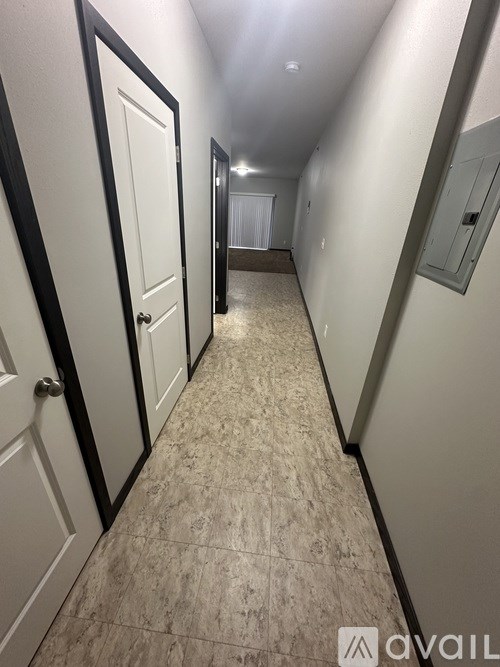 A hallway with a tiled floor and white walls.