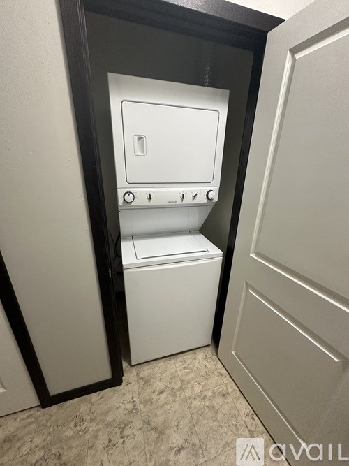 A white washing machine is in a small laundry room.