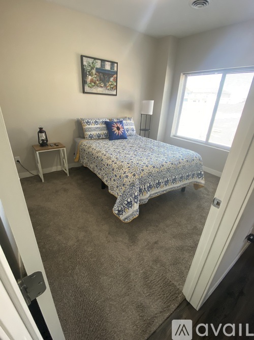 A bedroom with a bed, nightstand, and window.