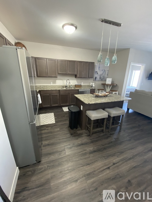 A kitchen with a refrigerator, a counter, and a dining table.