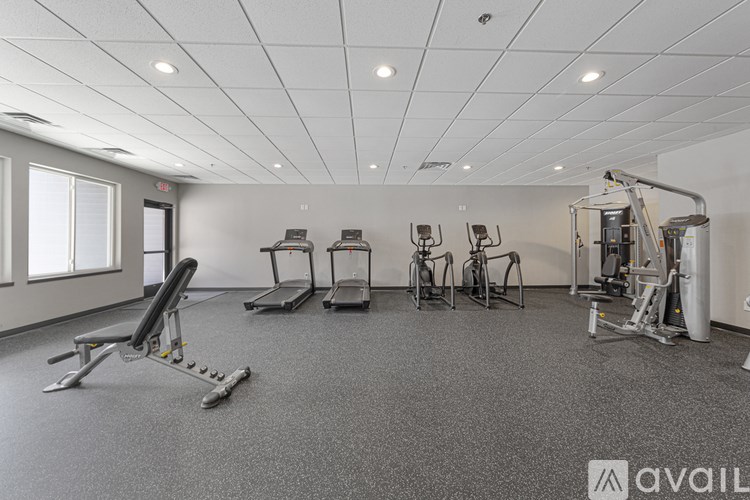 A gym with a variety of equipment including treadmills, weights, and a leg press machine.