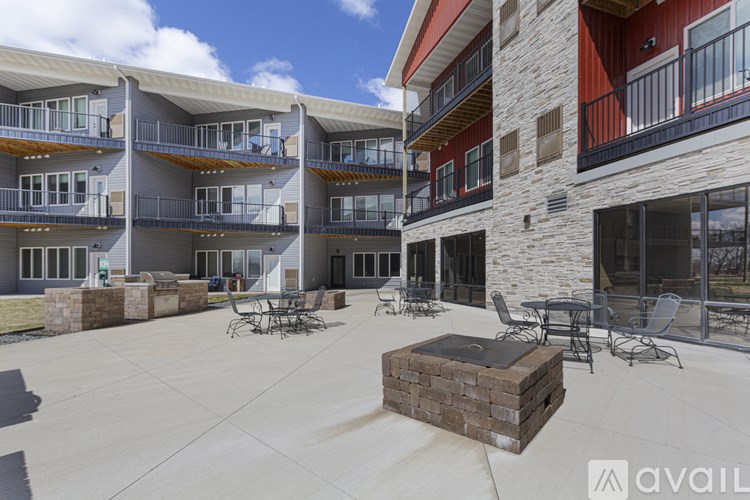 A courtyard with a fire pit and seating area in front of apartment buildings.