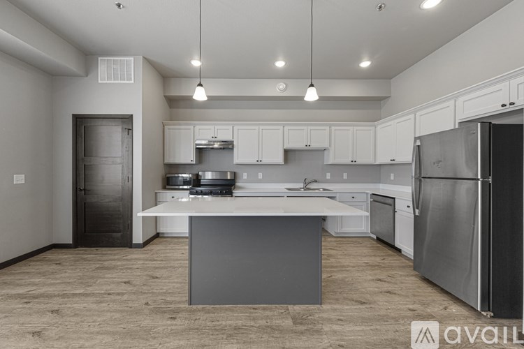 A modern kitchen with a large island and stainless steel appliances.