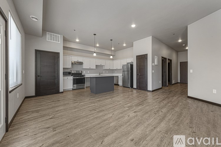 A spacious kitchen with wooden flooring and modern appliances.
