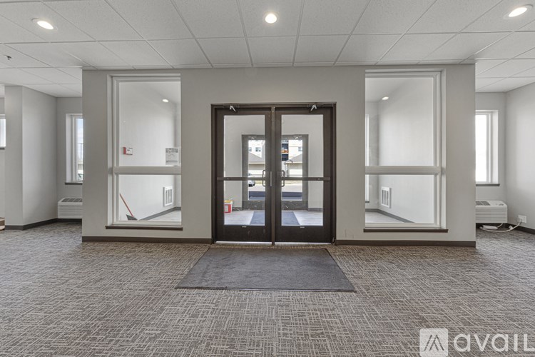 A large room with a black mat in front of a glass door.