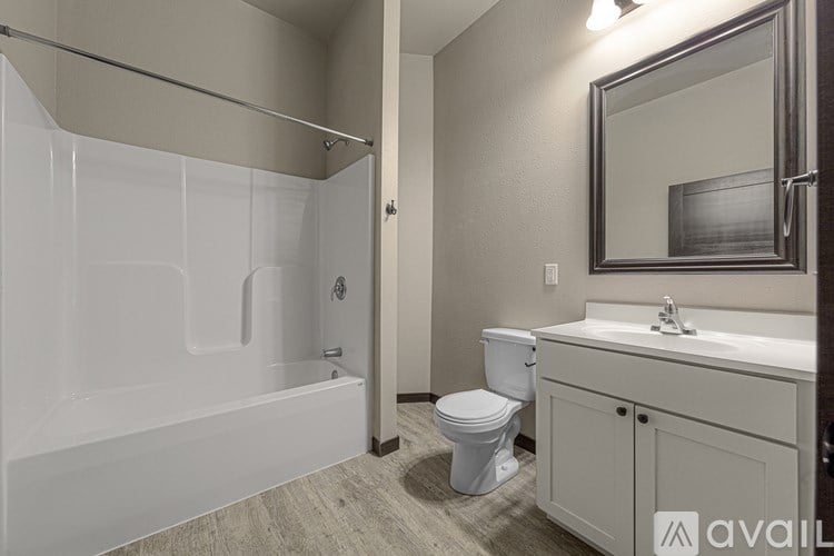 A bathroom with a white tub, toilet, and sink.