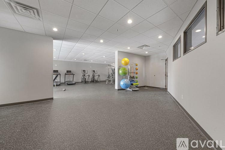 A spacious room with a grey floor and white walls, equipped with exercise equipment.