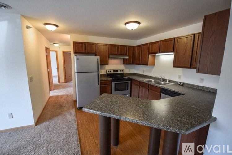 A kitchen with a granite countertop and wooden cabinets.