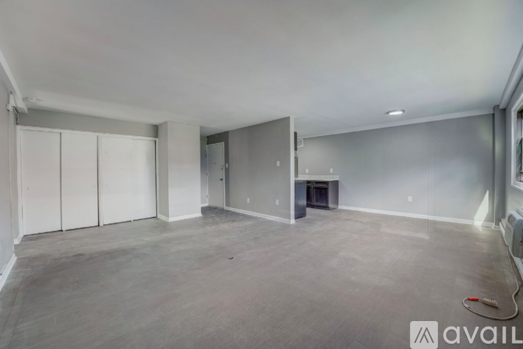 A spacious empty room with a fireplace and a wall-mounted TV.