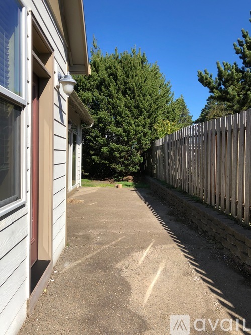 A house with a grey siding and a red window trim is shown.