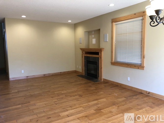 A living room with a fireplace and wood flooring.