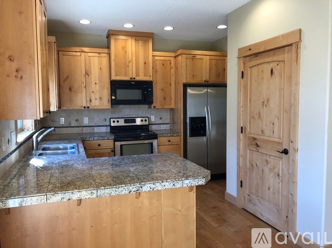 A kitchen with wooden cabinets and granite countertops.