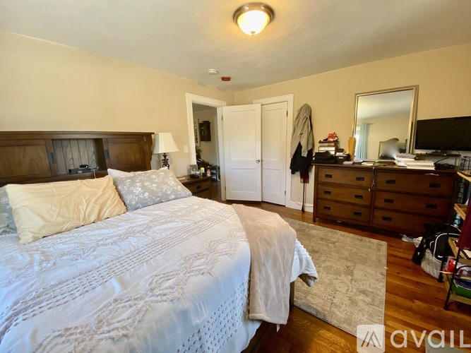 A bedroom with a large bed and a desk with a mirror.