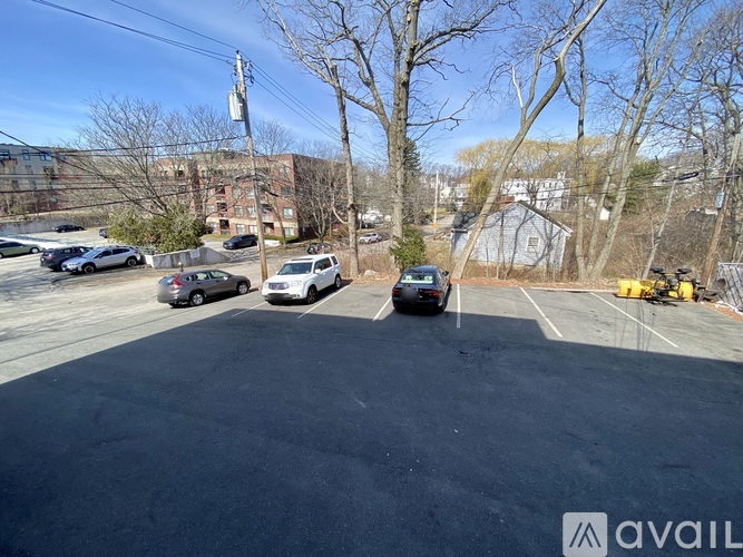 A parking lot with several cars and a building in the background.