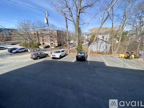 A parking lot with several cars and a building in the background.