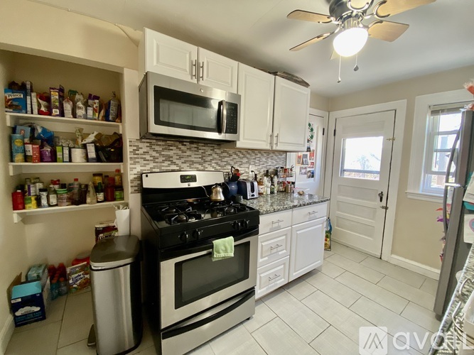 A kitchen with white cabinets and a black stove top.