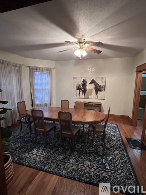 A dining room with a table and chairs.