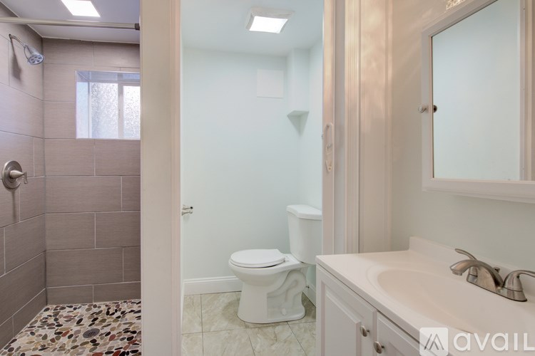 A bathroom with a toilet, sink, and shower.