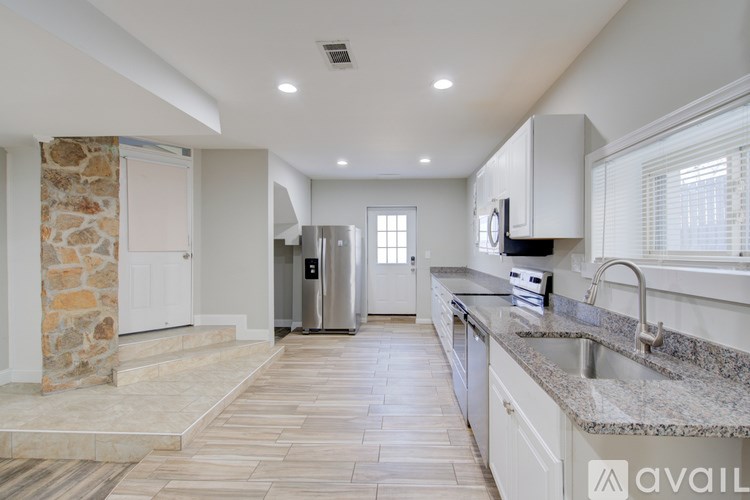 A kitchen with granite countertops and a stone pillar.