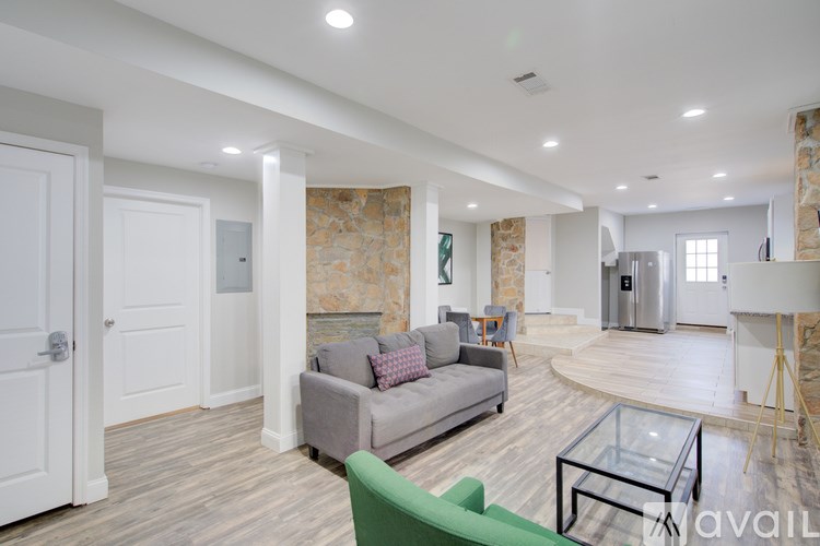 A living room with a grey couch and a glass coffee table.