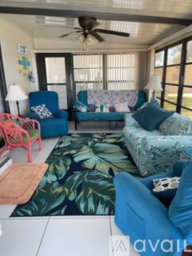 A living room with a blue couch and a green plant.