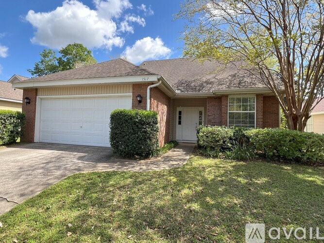 A house with a driveway and a tree in front.