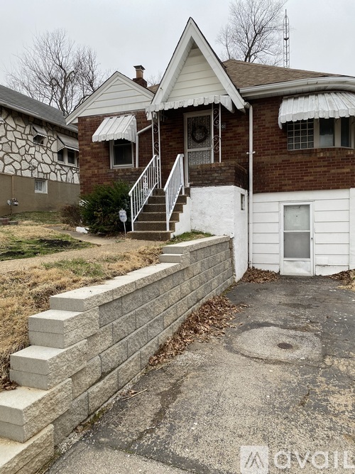 A house with a white front door and a brick wall.