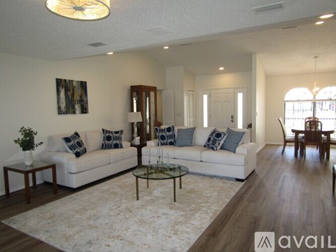 A living room with a white couch and a rug.