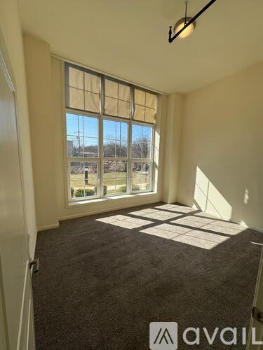 A room with a large window and a carpeted floor.
