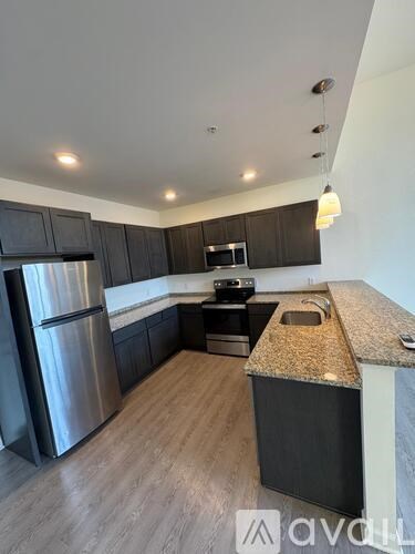 A kitchen with dark wood cabinets and stainless steel appliances.