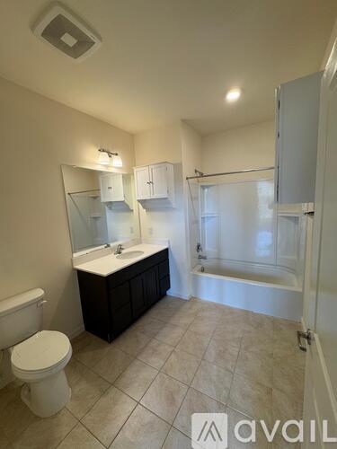 A bathroom with a toilet, sink, and bathtub.