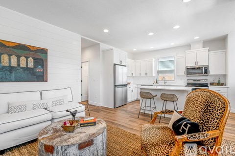 A living room with a leopard print chair and a white couch.