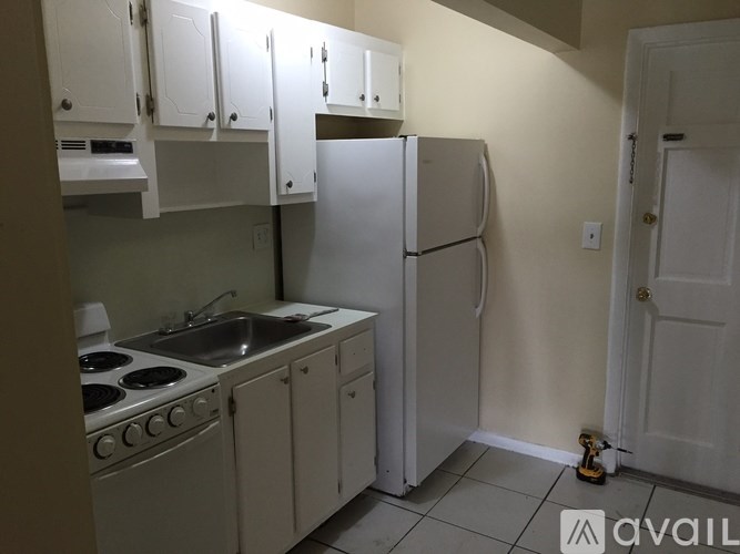 A kitchen with white appliances and cabinets.