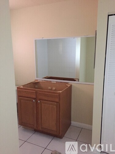 A bathroom with a wooden vanity and a mirror.