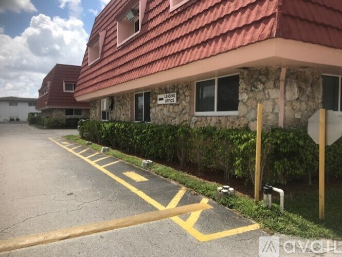A parking lot with a yellow line and a building in the background.