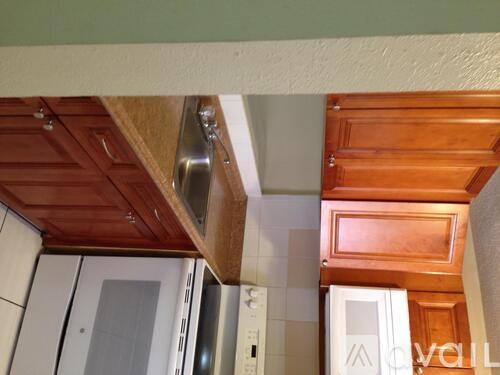A kitchen with wooden cabinets and a stainless steel range hood.