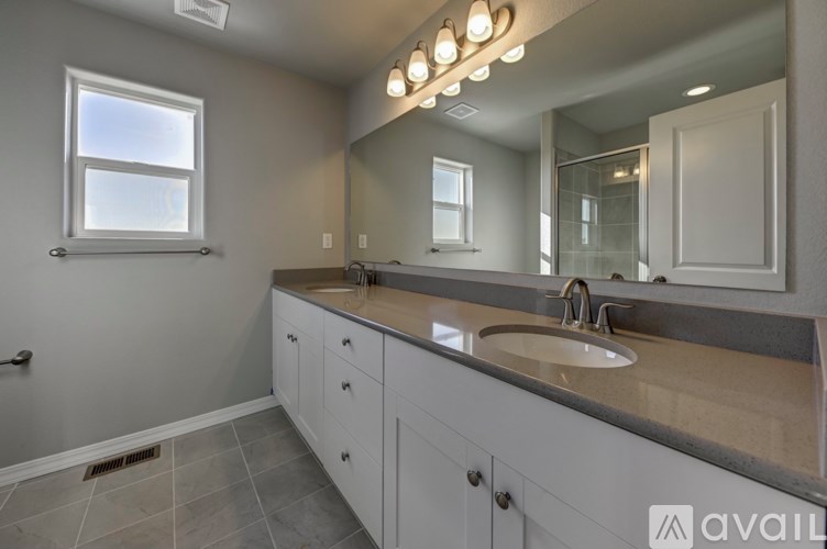 A bathroom with a sink, mirror, and a window.