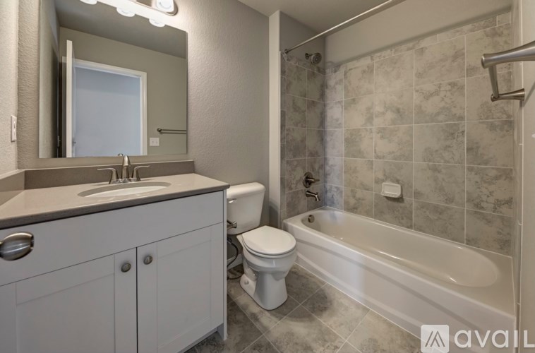 A bathroom with a tub, toilet, and sink.