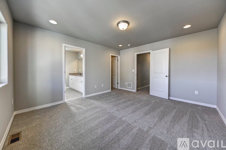A spacious room with a carpeted floor and a ceiling light.
