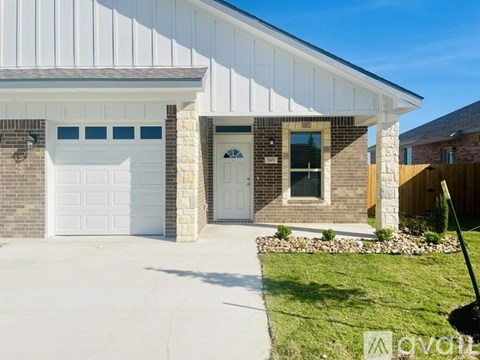 A house with a white garage door and a brick wall.