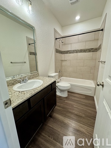 A bathroom with a sink, toilet, and bathtub.