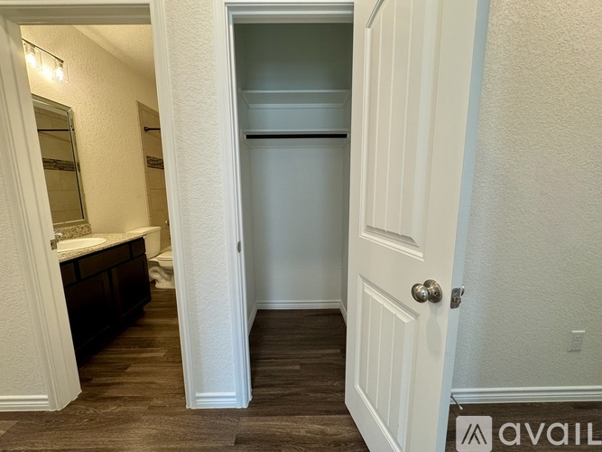 A white door is open to a small kitchen.