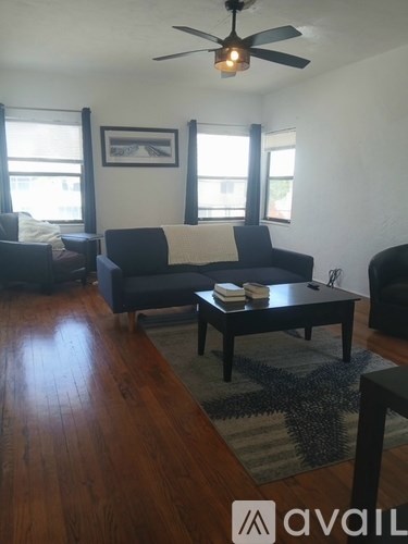 A living room with a couch, a coffee table, and a ceiling fan.