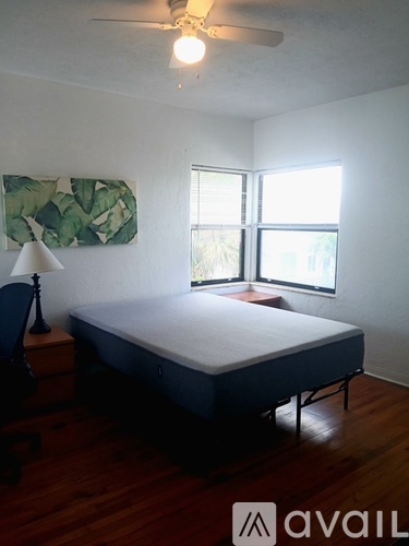 A bedroom with a bed, a chair, and a lamp.