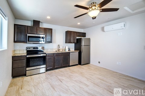 A kitchen with dark brown cabinets and stainless steel appliances.