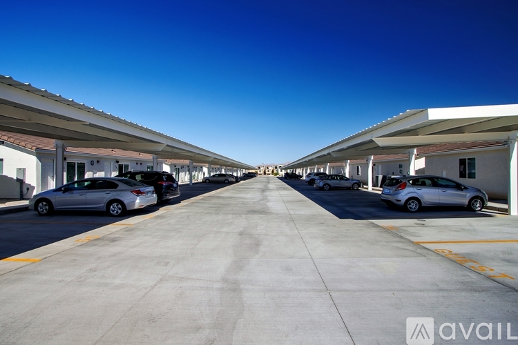A parking lot with cars parked under a roof.